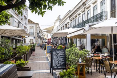 FARO, PORTUGAL - 27 Mart 2022: Faro 'da restoranları ve turistler için çok sayıda mağazası olan işlek cadde.