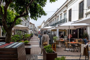 FARO, PORTUGAL - 27 Mart 2022: Faro 'da restoranları ve turistler için çok sayıda mağazası olan işlek cadde.