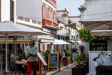 FARO, PORTUGAL - 27 Mart 2022: Faro 'da restoranları ve turistler için çok sayıda mağazası olan işlek cadde.