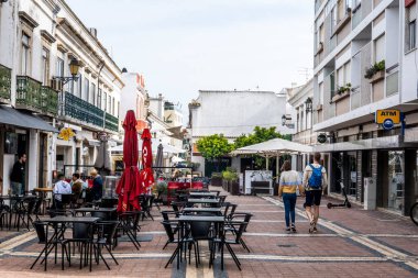 FARO, PORTUGAL - 27 Mart 2022: Faro 'da restoranları ve turistler için çok sayıda mağazası olan işlek cadde.