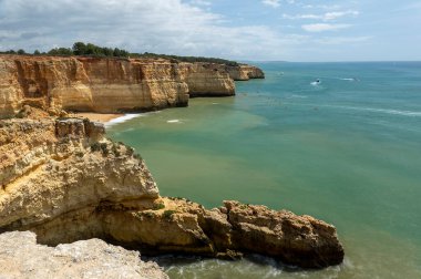 Portekiz 'in Algarve bölgesindeki güzel Benagil köyünün geniş bir manzarası var..