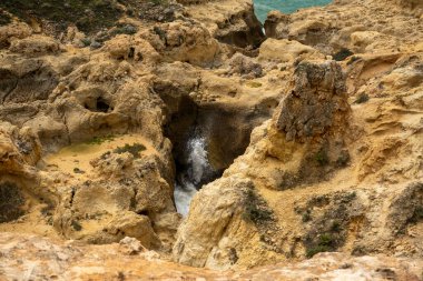 Portekiz 'in Algarve bölgesindeki kıyı şeridi kayalıklarında bulunan elementlerin aşınmasıyla oluşan doğal kum..