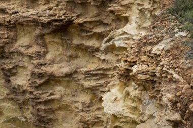 Portekiz 'in Algarve bölgesindeki kıyı şeridi kayalıklarında bulunan elementlerin aşınmasıyla oluşan doğal kum..