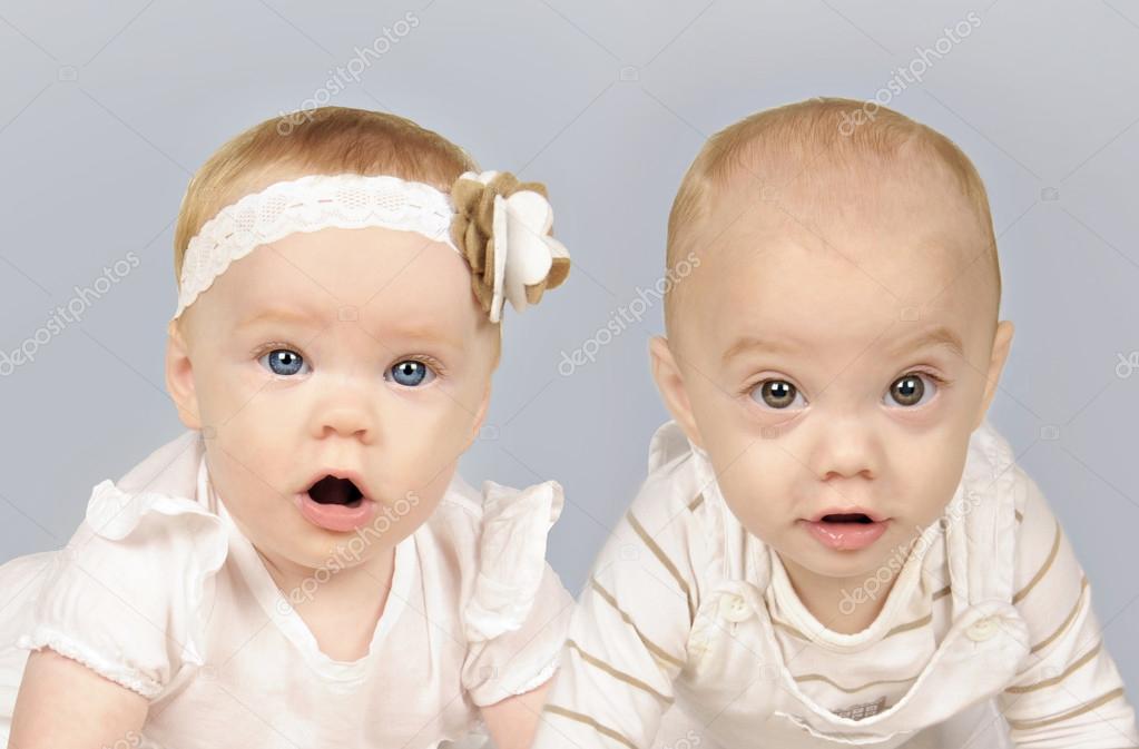 Twin baby brother and sister in white