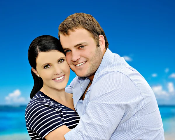 Beautiful young couple with sea in the background — Stock Photo, Image