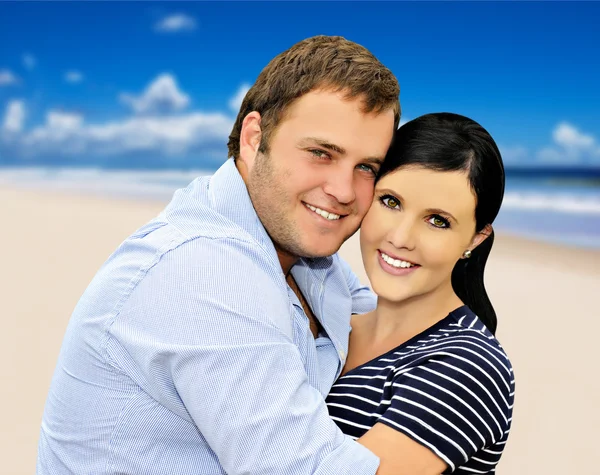 Beautiful young couple with sea in the background — Stock Photo, Image