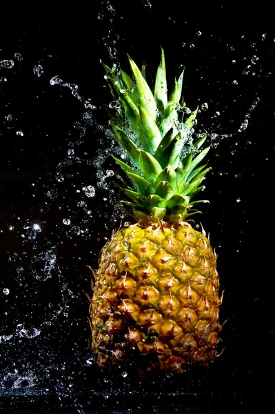 新鲜菠萝在水中滴在黑色背景上 — 图库照片