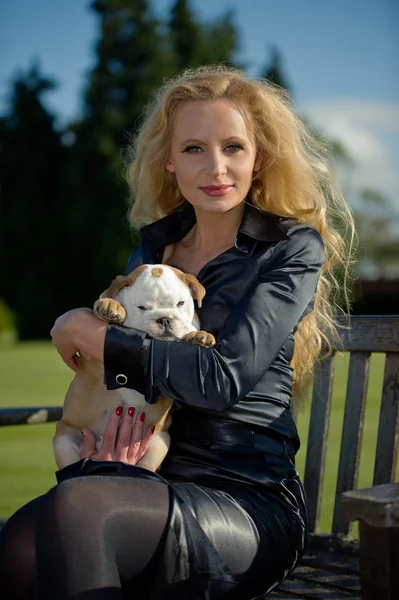 Hermosa mujer rubia sosteniendo un cachorro — Foto de Stock