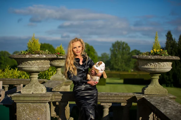 Beautiful blonde woman holding a puppy — Stock Photo, Image