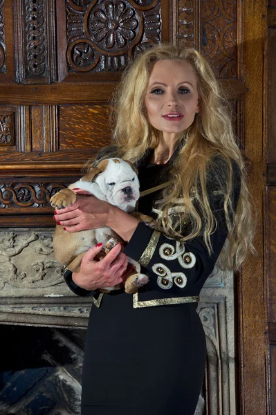 Femme blonde avec un chiot dans une chambre de luxe — Photo