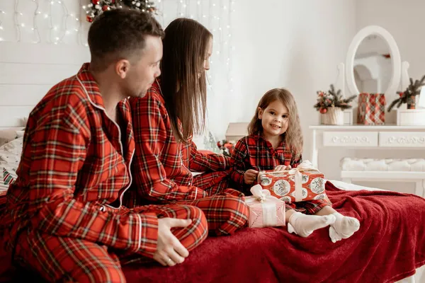 Glad Familj Röd Pyjamas Sitter Sängen Och Packar Upp Julklappar — Stockfoto