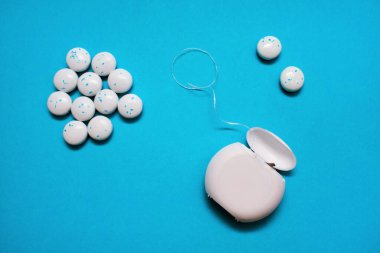 Diş ipi, diş temizliği ve mavi arka planda diş eti çiğnemek için. Ağız bakımı ve bakımı önleme kavramı. Diş bakımı ürünleri ve ağız sağlığı ürünleri