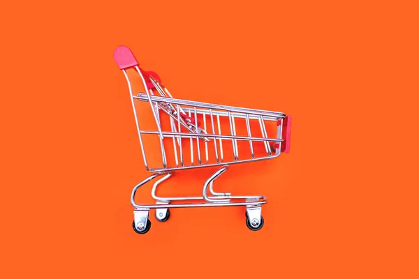 Small Trolley Transporting Groceries Supermarket Orange Background Concept Buying Goods — Stock Photo, Image