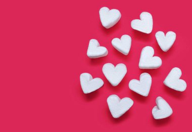 Kırmızı arka planda kalp şeklinde beyaz marşmelov. Sevgililer Günü konsepti lokum kalpler şeklinde. Havadar bir tatlı ya da sıcak çikolata için garnitür. Metin için boş alan