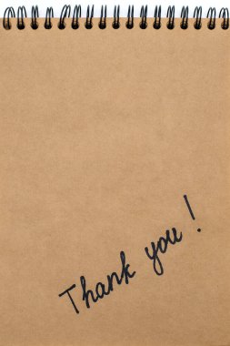 Not defterindeki kahverengi kağıda bir kalemle yazılmış bir yazı için teşekkür ederim. Bir yazıt biçiminde minnettarlık. Kahverengi kağıt üzerinde metin veya reklam için boş alan ile teşekkür ederim.