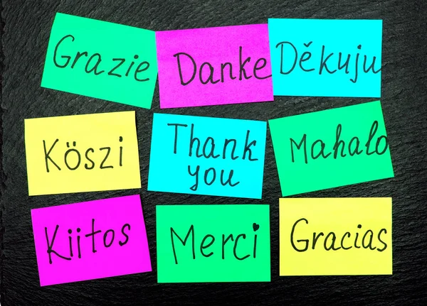 The word thank you in different languages of the world is written with a black marker on colored adhesive paper. Words of gratitude in the form of inscriptions in different languages of the world