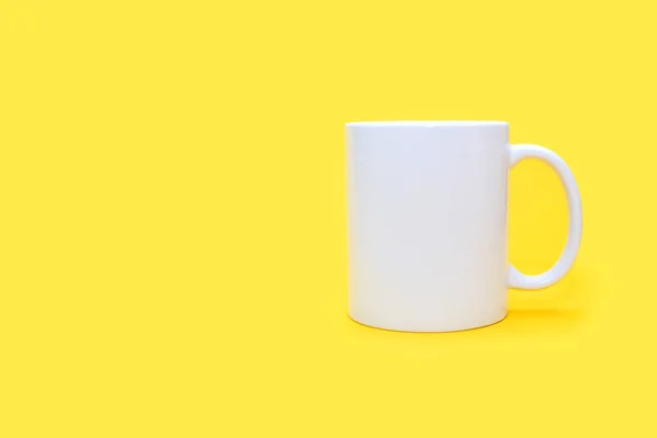 テキストのための自由なスペースを持つ黄色の背景に白いマグカップ 空の黄色の背景にドリンクと白のカップ カフェや軽食のコンセプト 広告やロゴを適用する可能性のある白いマグカップ — ストック写真