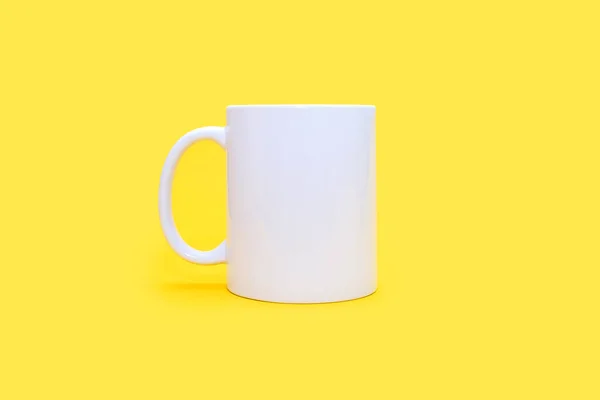 中央黄色背景上的白色杯子 白色杯子 任何饮料在一个空的黄色背景 咖啡或小吃的概念 可使用广告或标志的白色杯子 — 图库照片