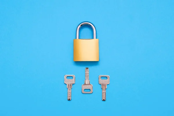 蓝色背景上有三个不同键的闭锁锁 蓝色背景上有三把钥匙的金黄色锁 选择打开锁的正确钥匙的概念 — 图库照片