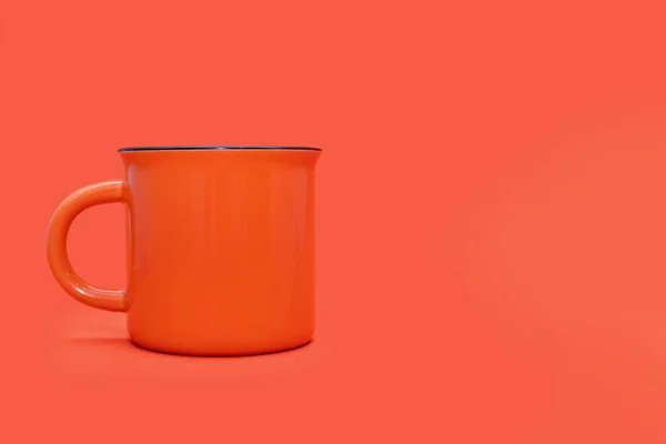 明るいオレンジの背景にオレンジのマグカップを無料でテキスト用に オレンジの背景にドリンク付きの大きなオレンジカップ 熱い飲み物を飲むという概念 鮮やかなカラフルなマグカップ画像 — ストック写真