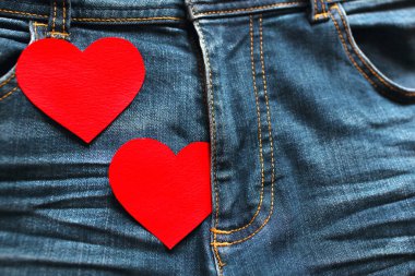 Kot pantolon arka planında iki kırmızı kalp. Samimiyet ve aşk ilişkileri kavramı. Metin için boş alan