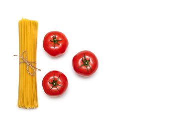 Çiğ spagetti ve beyaz arka planda üç kırmızı domates. Metin için boş yer var. Spagetti birikmiş ve geleneksel İtalyan yemeği için domates ve iple bağlanmış. Güzel yemek düzeni.