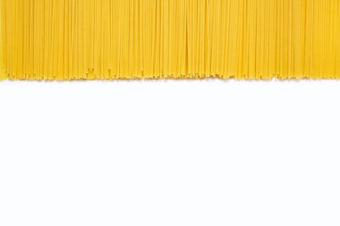 Yazı için boş yeri olan çiğ uzun spagetti arkaplanı. Uzun ve dar hamur parçaları şeklinde İtalyan klasik yemekleri. Beyaz arka planda bir sürü çiğ spagetti var.