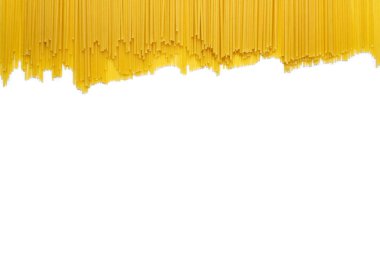 Rastgele boşluklarla doldurulmuş çiğ uzun spagetti arkaplanı. Uzun ve dar hamur parçaları şeklinde klasik bir İtalyan yemeği. Beyaz arka planda bir sürü çiğ spagetti var.