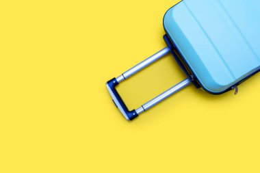 Mavi seyahat çantası sarı arka planda izole edilmiş. Metin için boş alan. Seyahat ve tatil konsepti. Ukrayna ulusal renkleri ve Ukrayna turizmi fikri. Taşınmak ya da iş gezisi