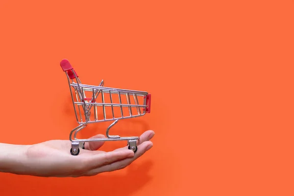 Small Shopping Trolley Hand Orange Background Close Concept Buying Selling — Photo