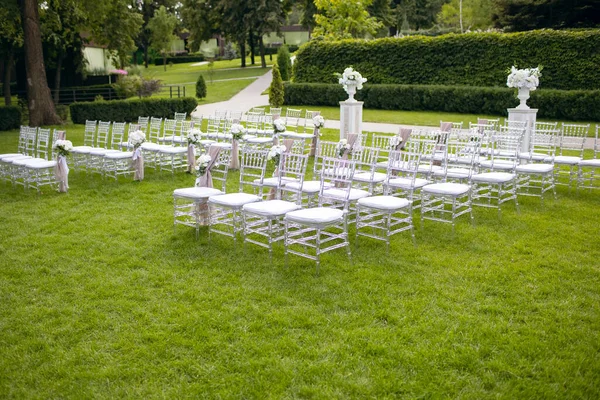 客人的白色椅子在绿色草坪上举行婚礼 — 图库照片