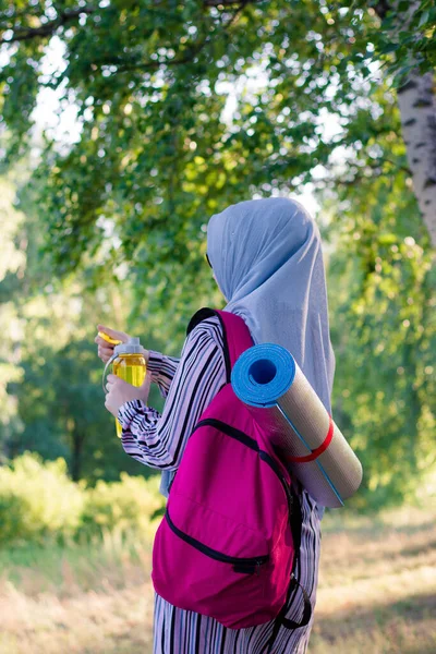 Sırt Çantalı Müslüman Bir Kadın Için Sarı Bir Şişeyle Ormanda — Stok fotoğraf