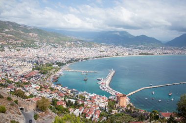 Türkiye 'de deniz, ağaçların arasından Alanya. Arka planda deniz feneri var. Yukarıdan görüntüle