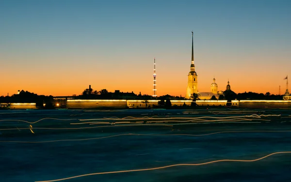 サンクトペテルブルクの白い夜の間に船からの光の痕跡を持つ澄んだ空に対して日没のピーターとポール要塞 宮殿堤防からの写真 — ストック写真