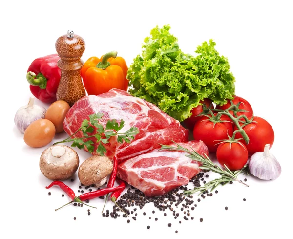 Natura morta con carne di maiale cruda e verdure fresche — Foto Stock