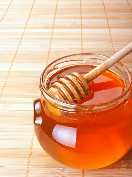 Tarro de vidrio de miel con rociador de madera — Foto de Stock