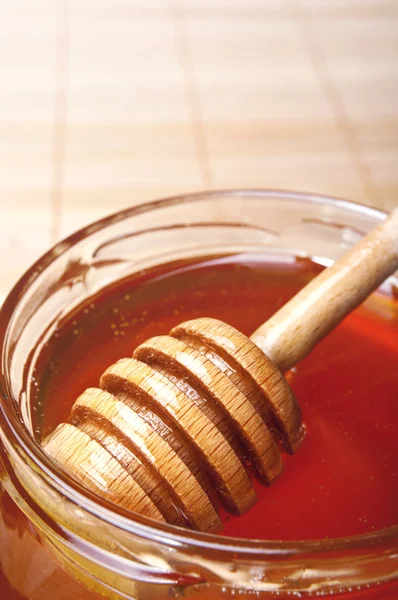 Frasco de vidro de mel com drizzler de madeira — Fotografia de Stock