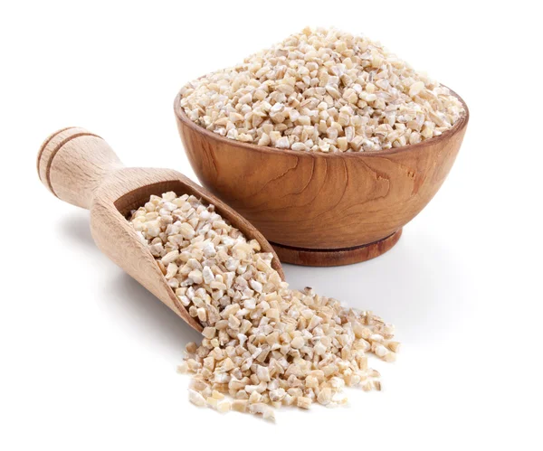 Barley grits in a wooden bowl isolated on white