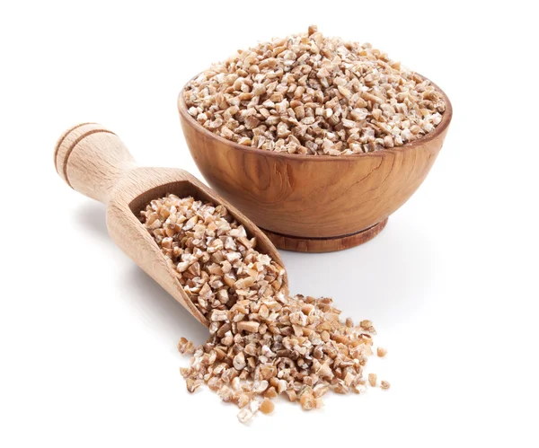 Wheat groats in a wooden bowl isolated on white — Stock Photo, Image