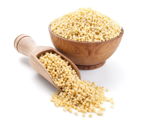 Millet in a wooden bowl isolated on white — Stock Photo, Image