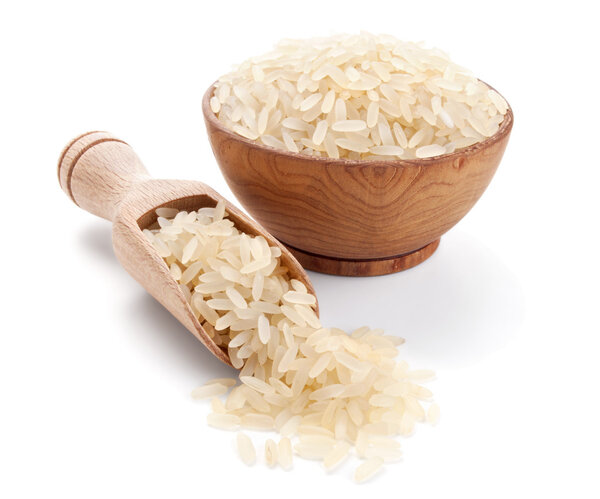 Parboiled rice in a wooden bowl isolated on white