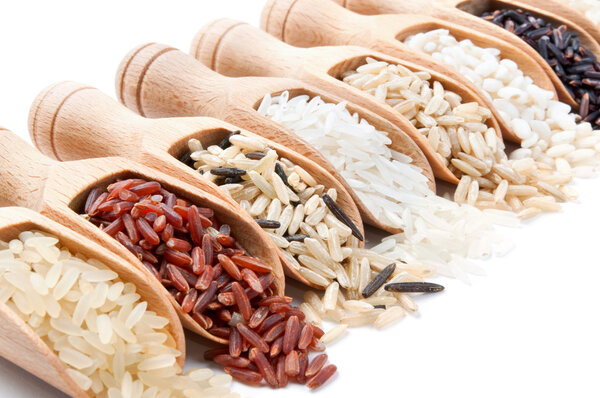 Wooden scoops with different rice types scattered from them