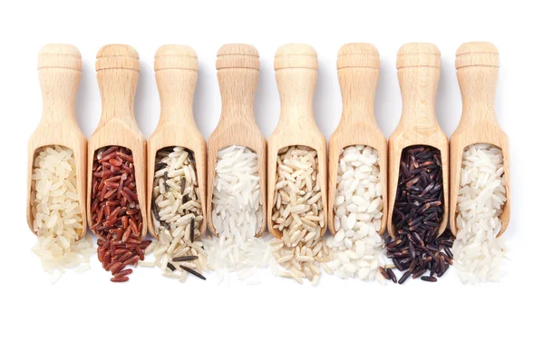 Dřevěné naběračky s různými rýže typy roztroušených od nich — Stock fotografie