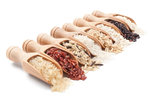 Houten scoops met verschillende rijst typen verspreid van hen — Stockfoto