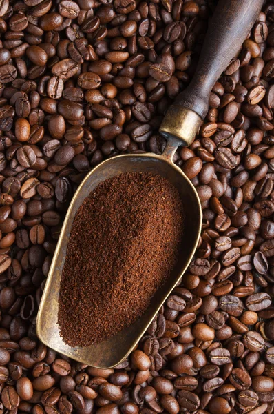 Vintage scoop with ground coffee on coffee beans — Stock Photo, Image