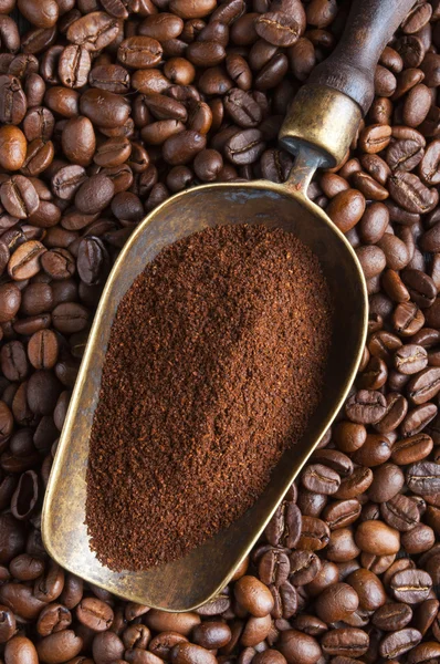 Vintage scoop with ground coffee on coffee beans — Stock Photo, Image