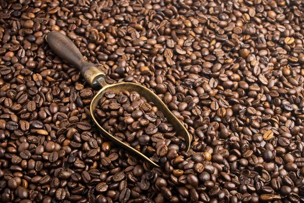 Grãos de café torrados com colher de bronze retrô — Fotografia de Stock