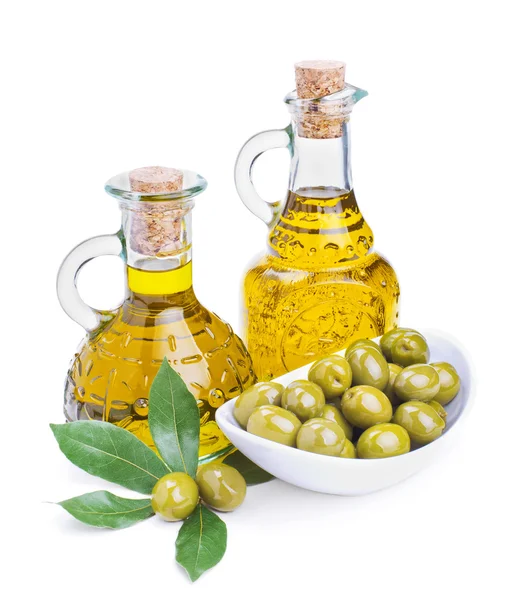 Bottiglie di olio di oliva e olive verdi con foglie — Foto Stock