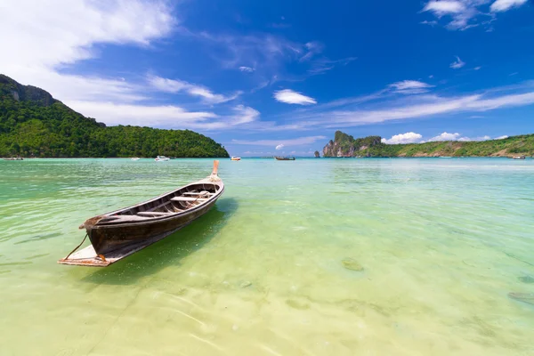Деревянная лодка на тропическом пляже . — стоковое фото