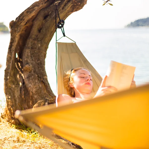 Леди читает книгу в гамаке. — стоковое фото